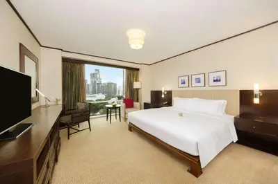 a hotel room with a large bed and a television at Conrad Bangkok Residences in Bangkok