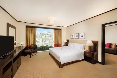 a hotel room with a bed and a large window at Conrad Bangkok Residences in Bangkok