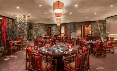 a restaurant with tables and chairs in a room at Conrad Bangkok Residences in Bangkok