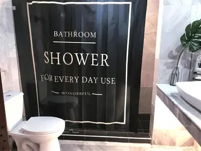 a black shower curtain in a bathroom with a toilet at Nego Home Ancient Inn in Bangkok