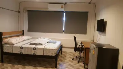 a bedroom with a bed and a large window at JS mansion in Bangkok