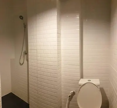 a white bathroom with a toilet and a shower at JS mansion in Bangkok