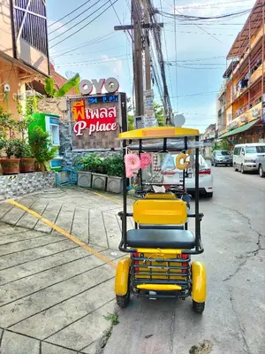 a yellow and black cart sitting on the side of a street at พีเพลส in Bangkok