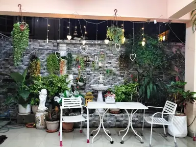 a table and chairs in front of a brick wall with plants at พีเพลส in Bangkok