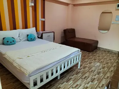 a bedroom with a bed with two pillows and a chair at พีเพลส in Bangkok