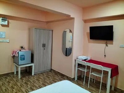 a room with a table and a tv on the wall at พีเพลส in Bangkok