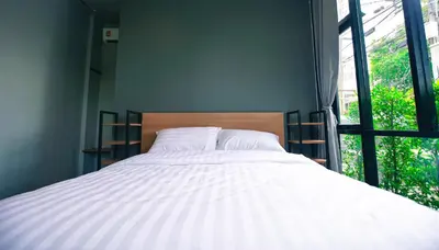 a bed in a room with a large window at Bed garden 26 in Bangkok