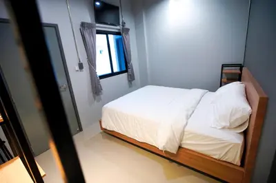 a bedroom with a bed with white sheets and a window at Bed garden 26 in Bangkok