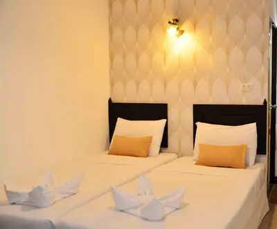two beds in a room with white sheets at Erawan House in Bangkok