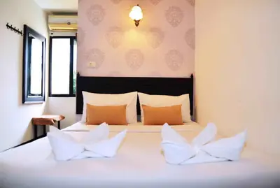 a bedroom with a large bed with two pillows at Erawan House in Bangkok