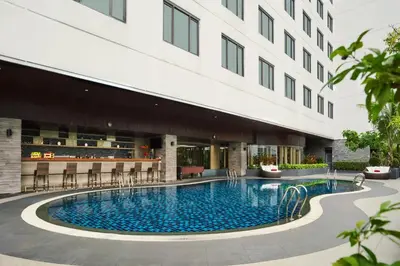 a swimming pool in front of a building at Avani Ratchada Bangkok in Bangkok