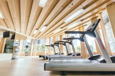 a gym with a row of treadmills and ellipticals at Avani Ratchada Bangkok in Bangkok