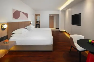 a bedroom with a large white bed and a table at Avani Ratchada Bangkok in Bangkok