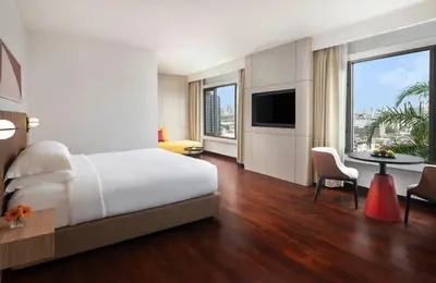a hotel room with a bed and a table and chairs at Avani Ratchada Bangkok in Bangkok