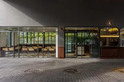 a building with glass doors with tables and chairs at Hotel Amber Sukhumvit 85 in Bangkok