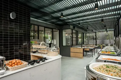 a kitchen with a bunch of food on display at Hotel Amber Sukhumvit 85 in Bangkok