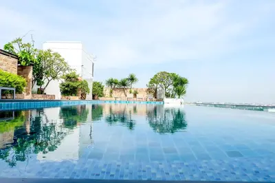 a swimming pool in a resort with blue water at Park Village Rama II in Bangkok