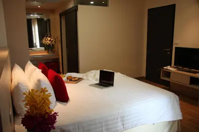 a bedroom with a bed with a laptop on it at Park Village Rama II in Bangkok