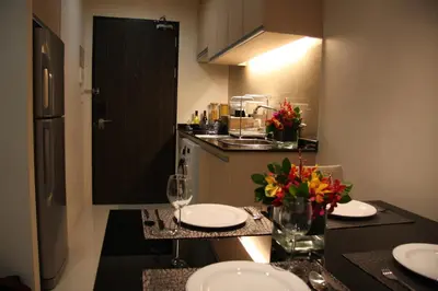 a kitchen with a table with plates and flowers on it at Park Village Rama II in Bangkok