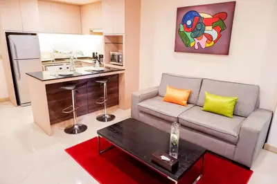 a living room with a couch and a kitchen at Park Village Rama II in Bangkok