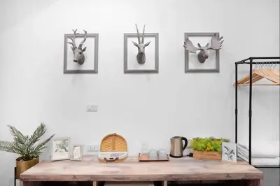 a room with a wooden table with antlers on the wall at Hide and Seek Boutique Hometel in Bangkok