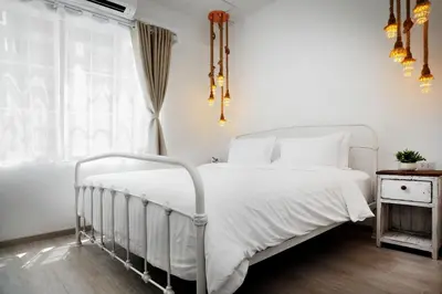 a bedroom with a white bed and a window at Hide and Seek Boutique Hometel in Bangkok