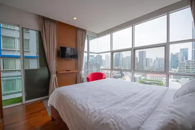 a bedroom with a bed and a large window at Prime 11, High Floor Over Pool, 2 Br, 2 Balcony in Bangkok