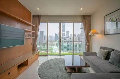 a living room with a couch and a flat screen tv at Prime 11, High Floor Over Pool, 2 Br, 2 Balcony in Bangkok