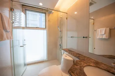 a bathroom with a toilet and a shower and a sink at Prime 11, High Floor Over Pool, 2 Br, 2 Balcony in Bangkok