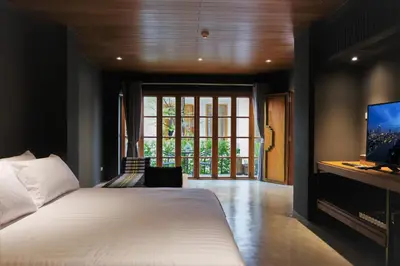 a bedroom with a white bed and a tv at Vali Villa Bangkok in Bangkok