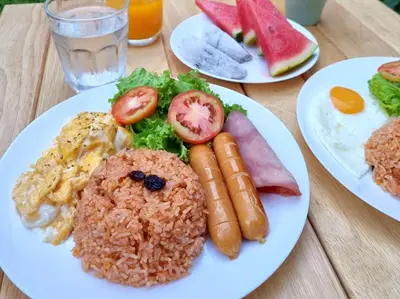 three plates of food on a wooden table at Vali Villa Bangkok in Bangkok
