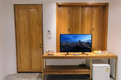 a desk with a television on top of it at Vali Villa Bangkok in Bangkok