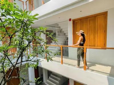a woman standing on the balcony of a building at Vali Villa Bangkok in Bangkok