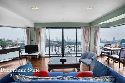 a living room with a blue couch and a balcony at Baan Wanglang Riverside, Bangkok in Bangkok