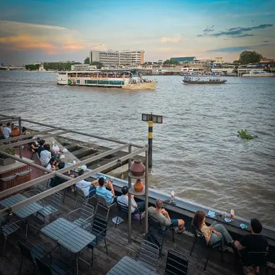 a group of people sitting on a boat on the water at Baan Wanglang Riverside, Bangkok in Bangkok