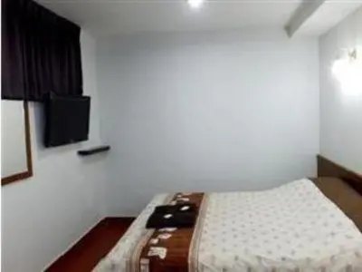 a bedroom with a bed with a tv on the wall at Orchid Inn in Bangkok