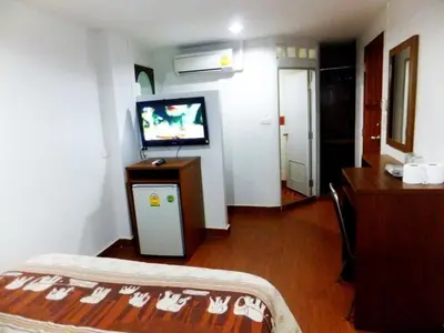 a room with a bed and a tv in a room at Orchid Inn in Bangkok
