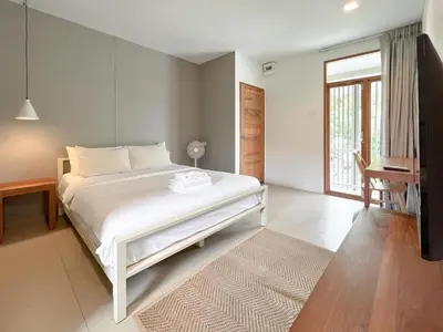 a bedroom with a white bed and a window at SUNKISS in Bangkok Noi