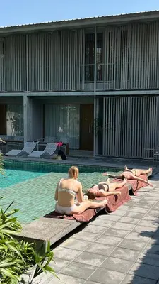 a group of people laying on towels in a swimming pool at SUNKISS in Bangkok Noi