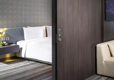a bedroom with a white bed and a chair at Holiday Inn Bangkok Sukhumvit by IHG in Bangkok