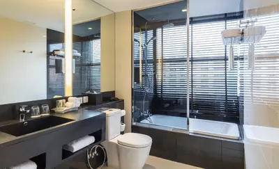 a bathroom with a toilet and a sink and a tub at Holiday Inn Bangkok Sukhumvit by IHG in Bangkok