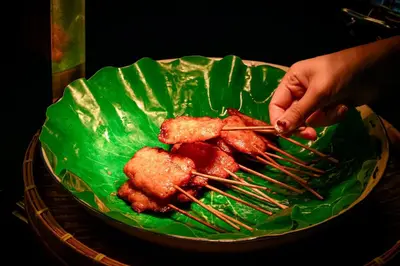 a person is holding a plate of food with chopsticks at Holiday Inn Bangkok Sukhumvit by IHG in Bangkok