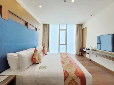 a bedroom with a large bed and a television at On 8 Sukhumvit Nana Bangkok in Bangkok