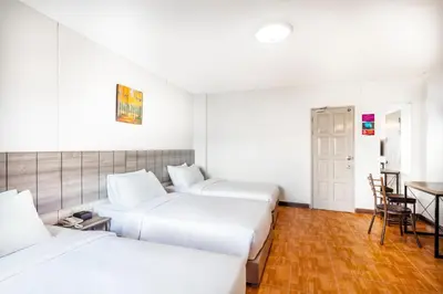 a hotel room with three beds and a table at Livotel Express Hotel Bang Kruai Nonthaburi - No Parking in Nonthaburi
