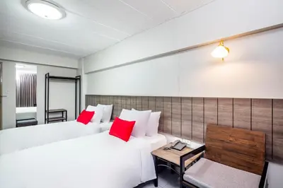 a hotel room with two beds and a table at Livotel Express Hotel Ramkhamhaeng 50 Bangkok - No Parking in Bangkok