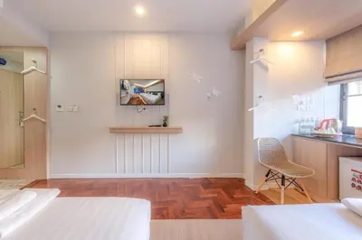a room with white walls and a wooden floor at Tori Prestige Bangkok Hotel in Bangkok
