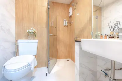 a bathroom with a toilet and a shower and a sink at Tori Prestige Bangkok Hotel in Bangkok