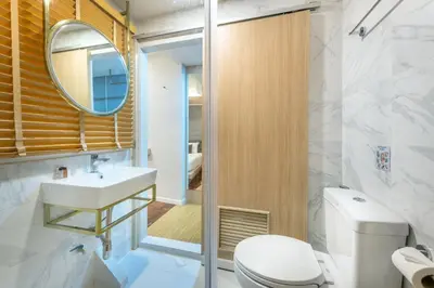 a bathroom with a toilet and a sink and a mirror at Tori Prestige Bangkok Hotel in Bangkok
