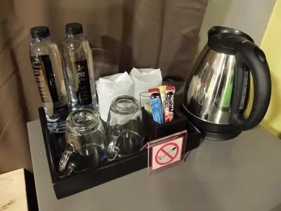 a tray with bottles and glasses on a table at Bed in Beyt Boutique Hotel in Nonthaburi