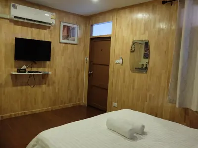 a bedroom with a bed and a flat screen tv at Bed in Beyt Boutique Hotel in Nonthaburi